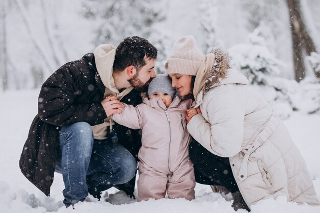 눈이 가득한 겨울 숲에서 작은 딸과 함께 젊은 가족