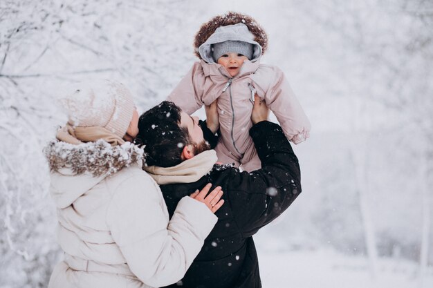 雪だらけの冬の森で幼い娘と若い家族