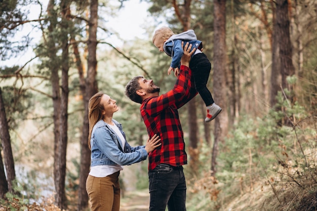 Foto gratuita giovane famiglia con figlio piccolo nella foresta