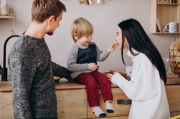 Foto gratuita giovane famiglia con figlio piccolo in cucina a natale