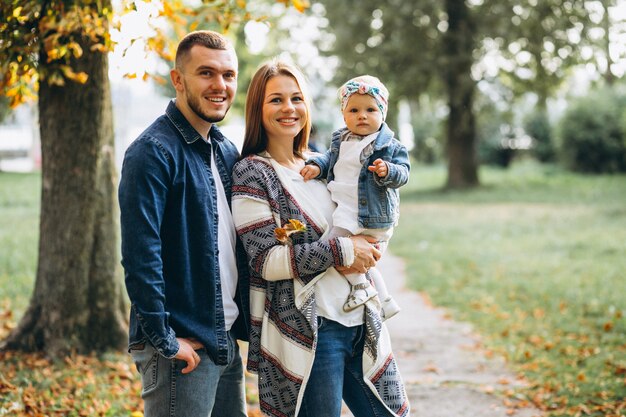 Young family with their small daughter in autumn park