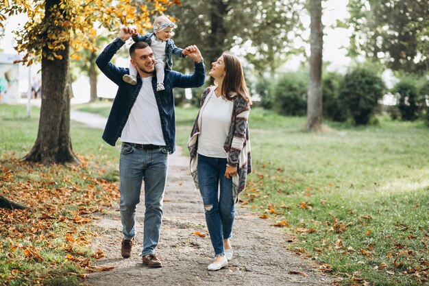 Young family with their small daughter in autumn park