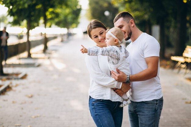 Young family with their small daughter in autumn park