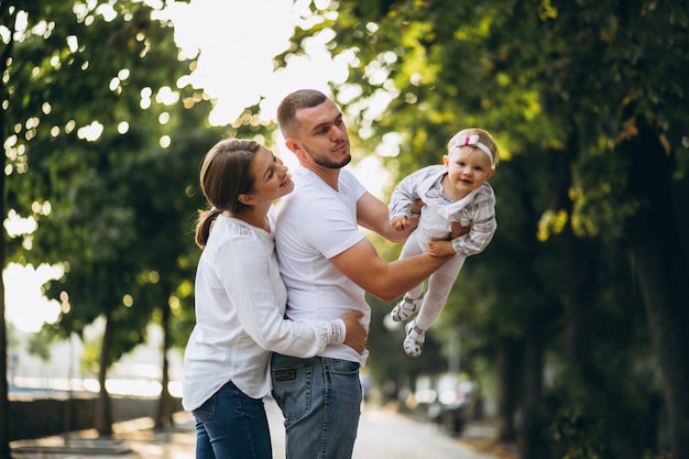 Young family with their small daughter in autumn park