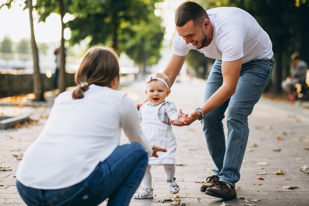 Young family with their small daughter in autumn park