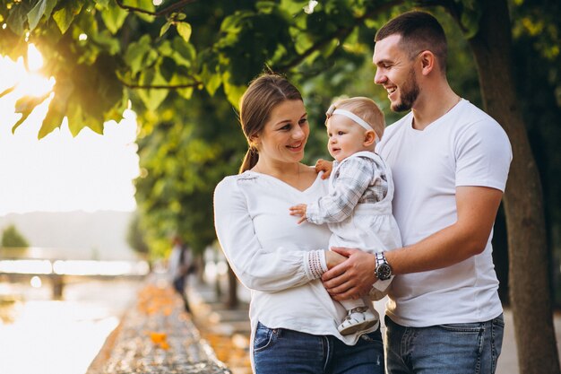 Young family with their small daughter in autumn park