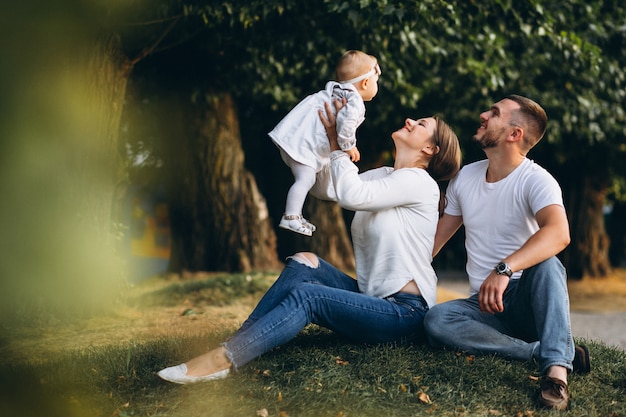 young family with their small daughter in autumn park