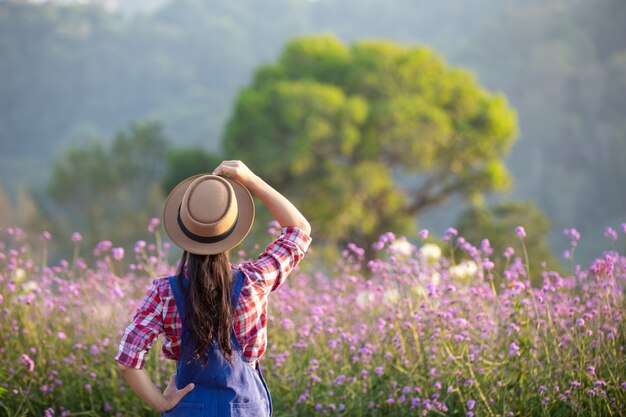 The young farmer admires the flowers in the garden.