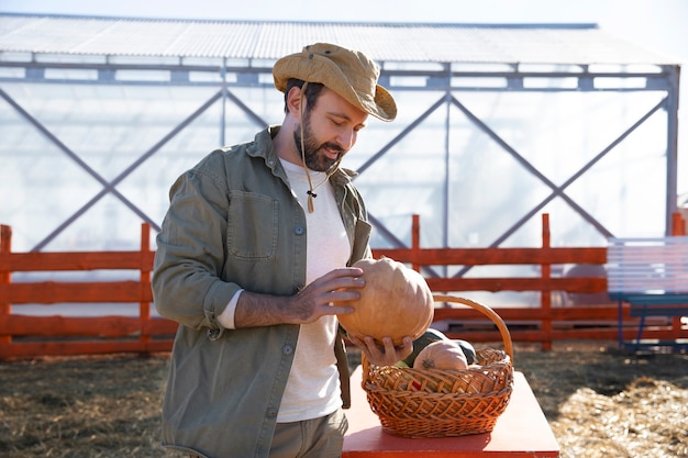 Young farmer holding basket with vegetables from his farm