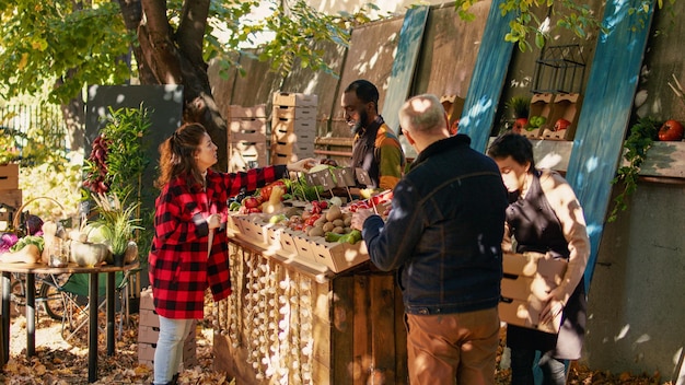 Free photo young farmer serving client with various produce