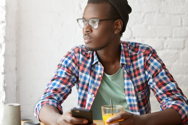 カフェに座っている若いおしゃれな男