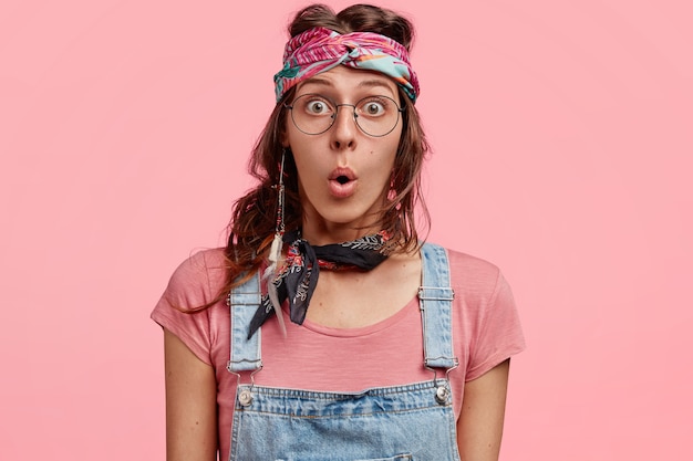 Young fashionable woman in colorful bandana and overalls