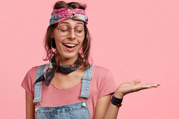 Young fashionable woman in colorful bandana and overalls