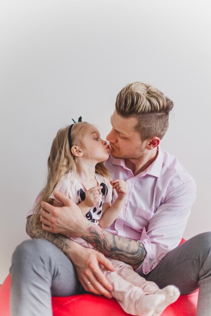 Young father kissing his daughter