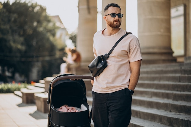Young father walking out with his baby in a baby carriage