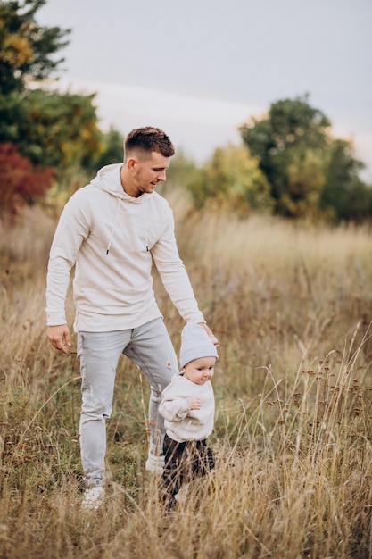 Young father with little son in field