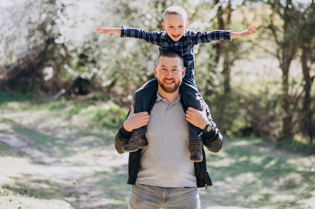 Young father with little son in the woods