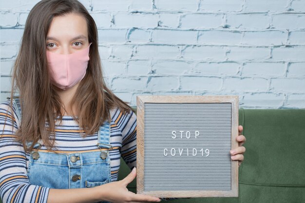 Young female activist holding a covid related poster