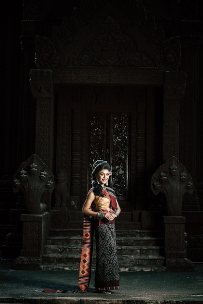 Free photo young female actress wearing beautiful ancient costumes, in ancient monuments, dramatic style. perform on legend love popular story, thai isan folktale called 