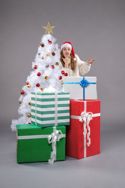 クリスマスの周りの若い女性は灰色のプレゼント