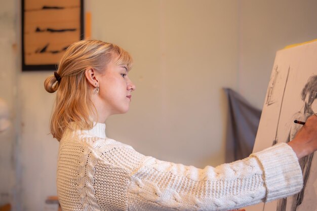 young female artist painting on easel in studio art concept a woman draws