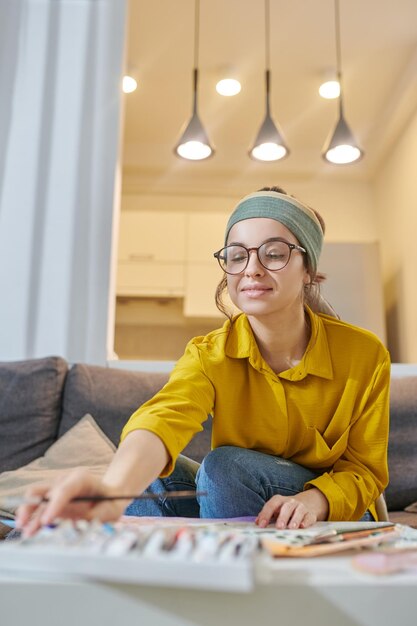 A young female artist in a studio looking inspired