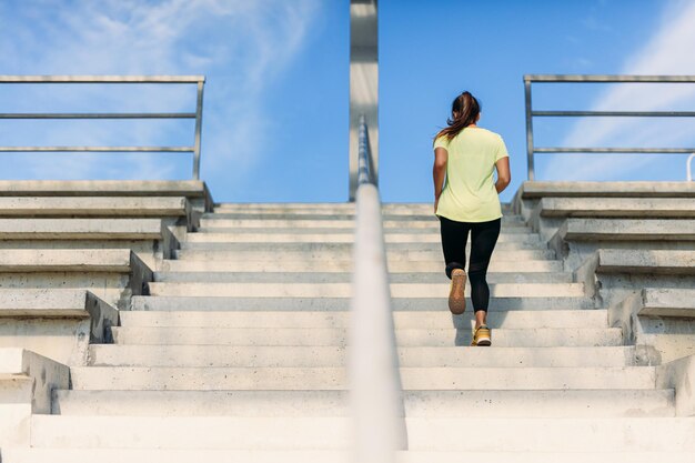 Free photo young female athlete doing run up at local stadium