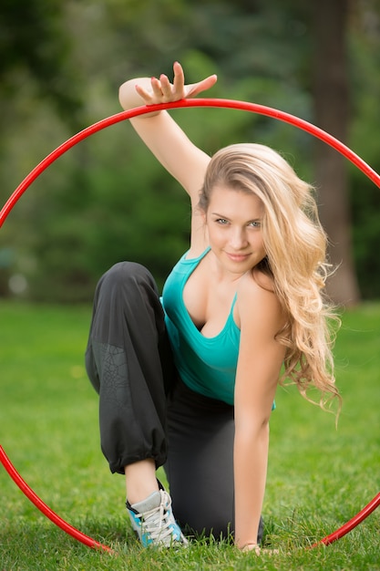 Young female athlete with hula hoop in the park