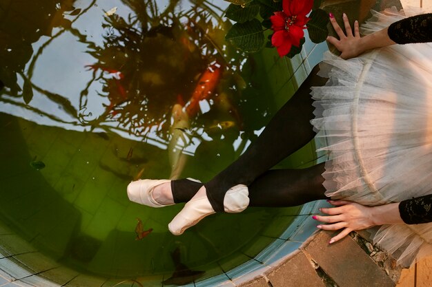 실내 식물원에 있는 수영장 근처에서 쉬고 있는 젊은 여성 발레리나