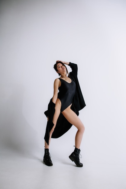 흰색 스튜디오 벽에 검은 bodysuit에서 젊은 여성 발레 댄서