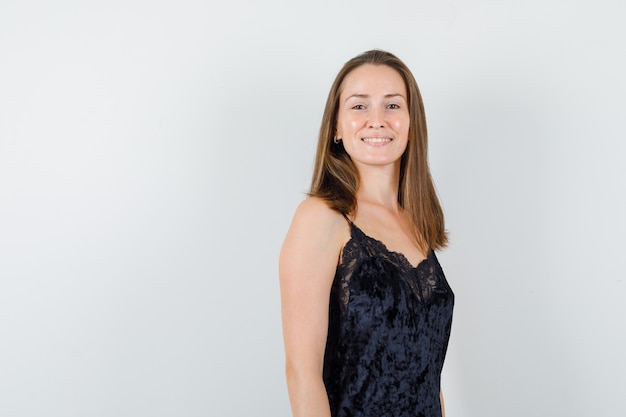 Young female in black singlet looking at camera and looking cheery