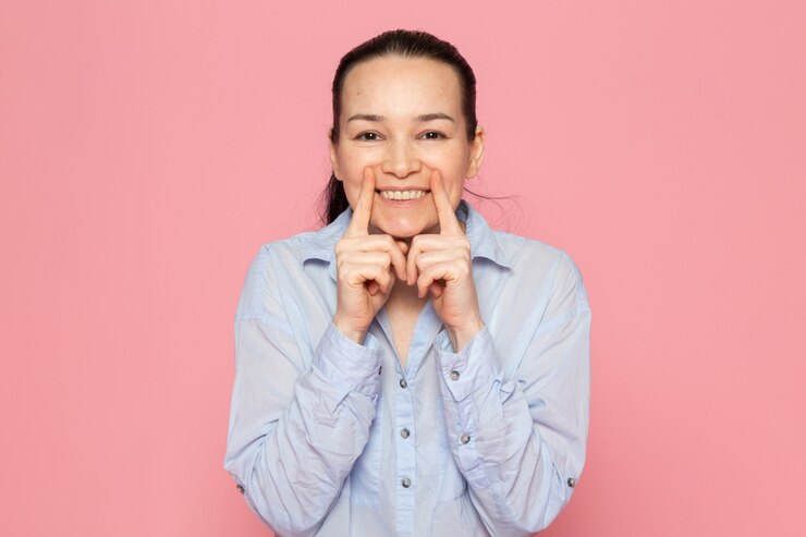 無料Photo ピンクの壁でポーズ青いシャツの若い女性