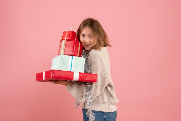 Giovane donna che trasportano regali di natale in rosa