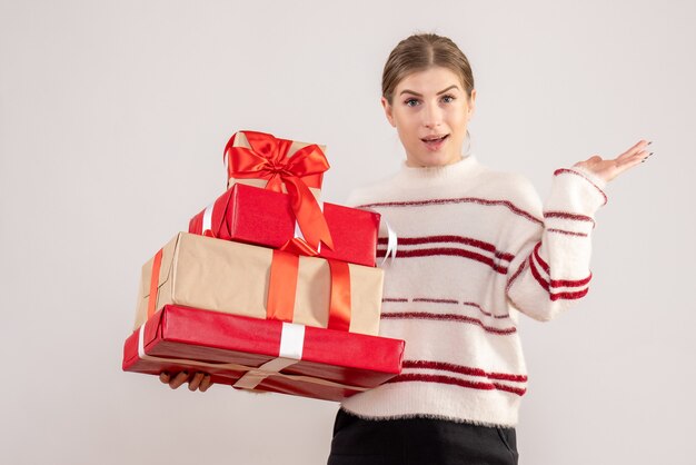 young female carrying xmas presents on white