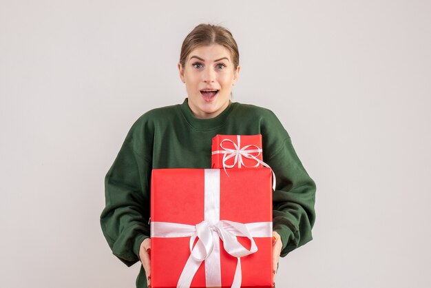 白でクリスマスプレゼントを運ぶ若い女性