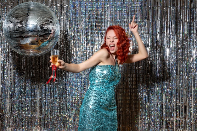 밝은 디스코 공 파티에서 새해를 축하하는 젊은 여성