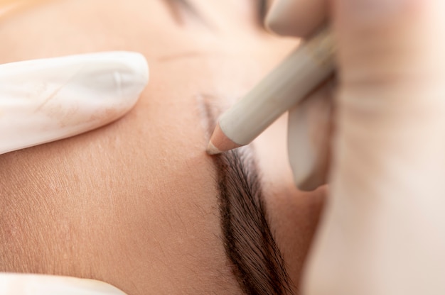 Free photo young female client going through a microblading procedure