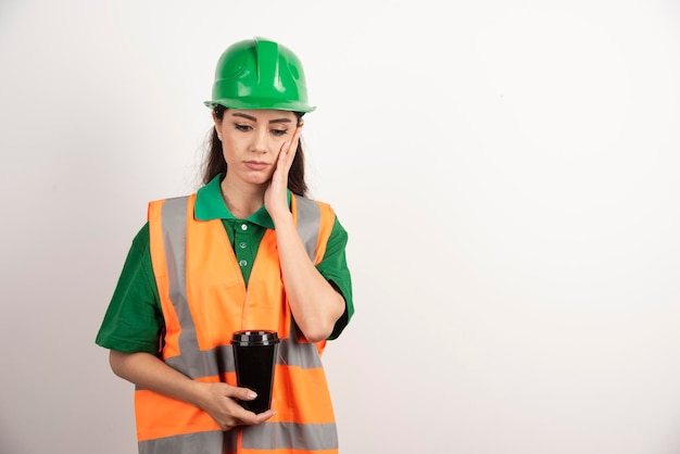 Young female constructor holding black cup. High quality photo