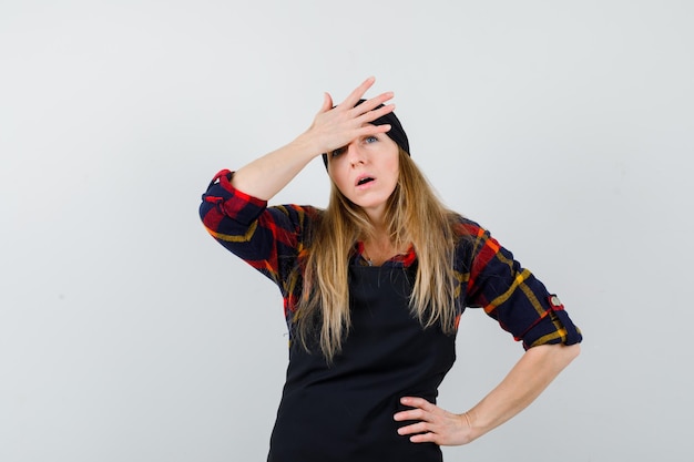 Young female cook in a black apron being sad