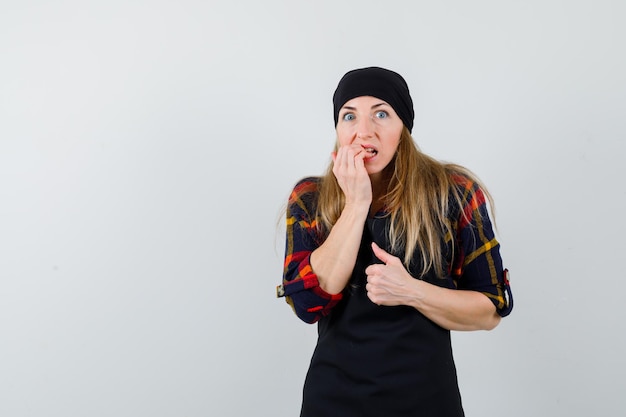 Young female cook in a black apron being scared