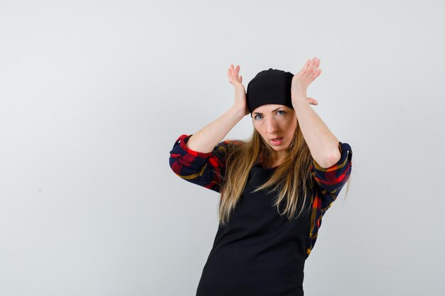 Young female cook in a black apron being stressed