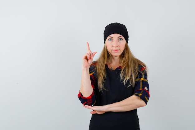 Young female cook in a black apron