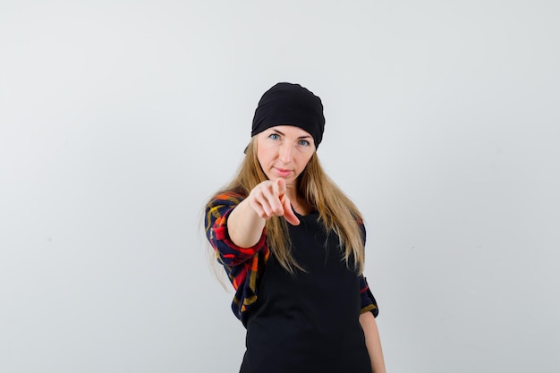 Young female cook in a black apron