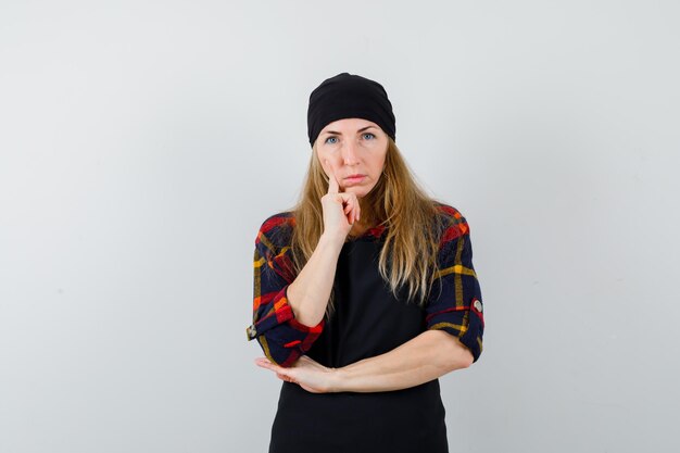 Young female cook in a black apron