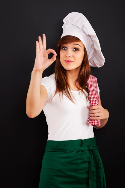 OKサインを示す若い女性の料理人