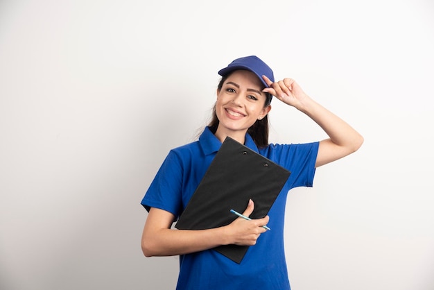 Free photo young female courier in blue scrubs holding a clipboard. high quality photo
