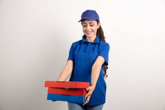 Young female courier with cardboard of pizza and clipboard