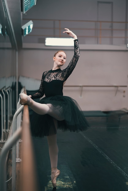 Free photo young female dancer of classic ballet practising in the dance studio