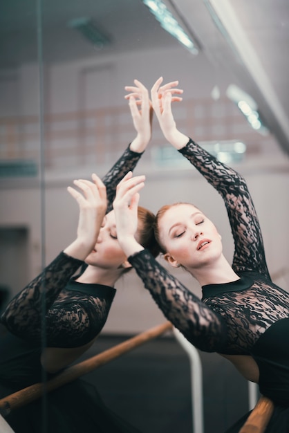 Young female dancer of classic ballet practising in the dance studio