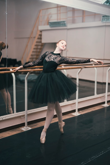 Young female dancer of classic ballet practising in the dance studio